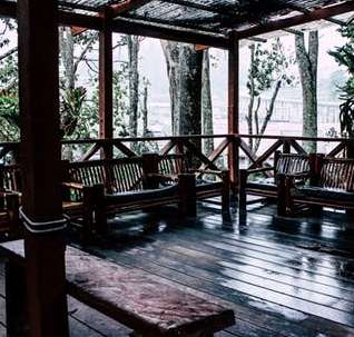 Wooden sumer house with benches in the rain