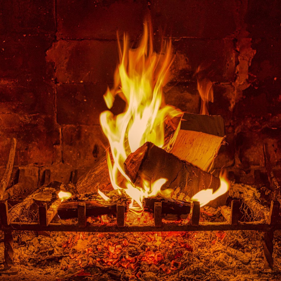 Open wood fire in old brick fireplace