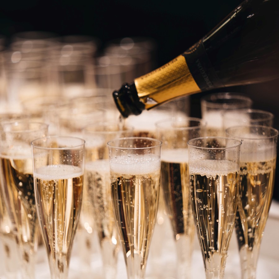 pouring a tray of champagne glasses by alexander-naglestad-xzKtOI1Cnxo-unsplash