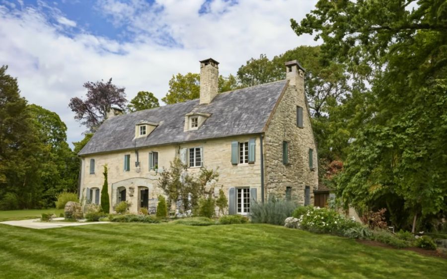 An old stone barn in the woods, converted to a high end home with a lush garden Ideogram AI image